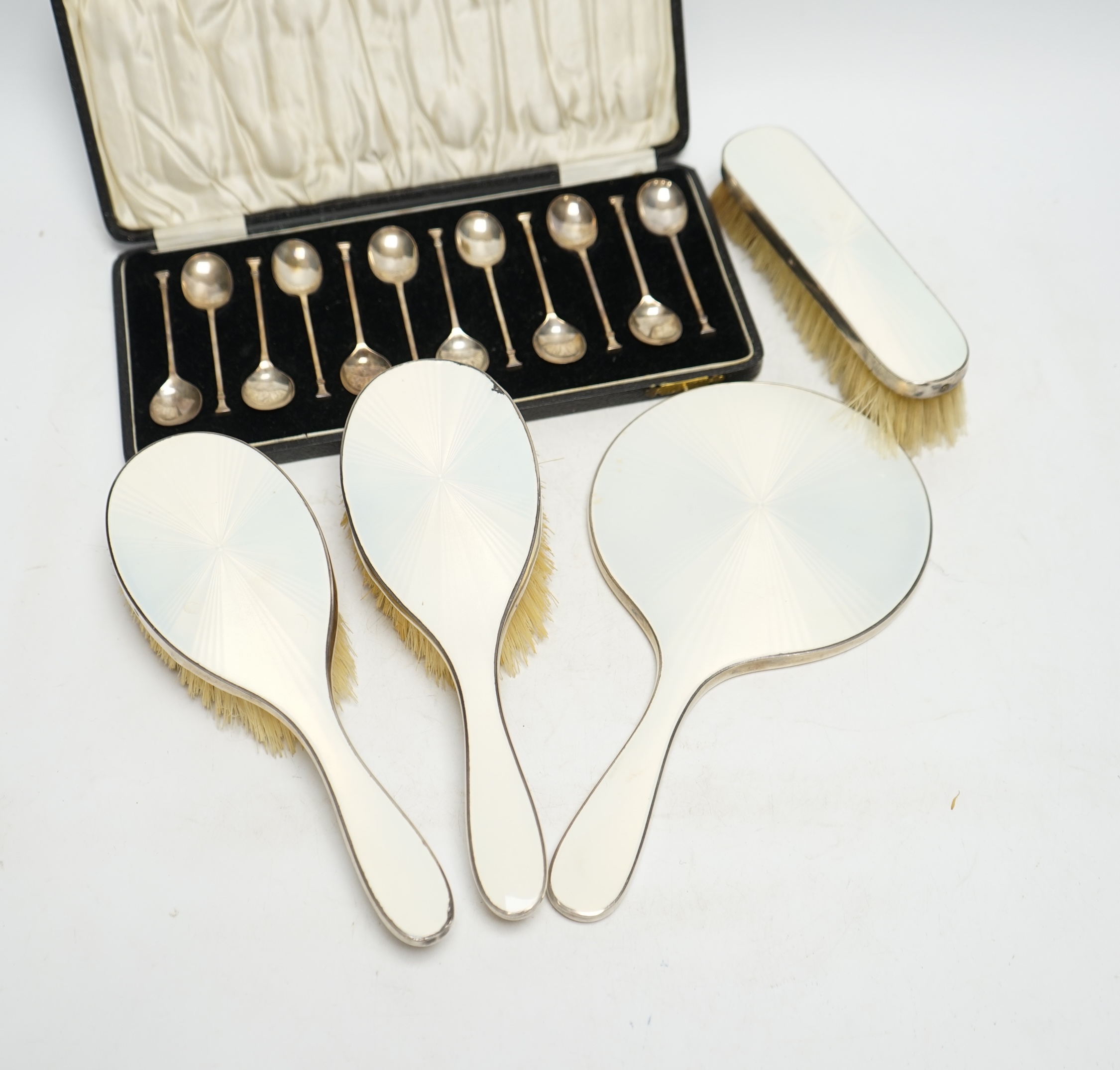 A cased set of twelve George V silver teaspoons, William Suckling Ltd, Birmingham, 1928, 90mm, together with a 1930's silver and enamel mounted for piece mirror and brush set. Condition - poor